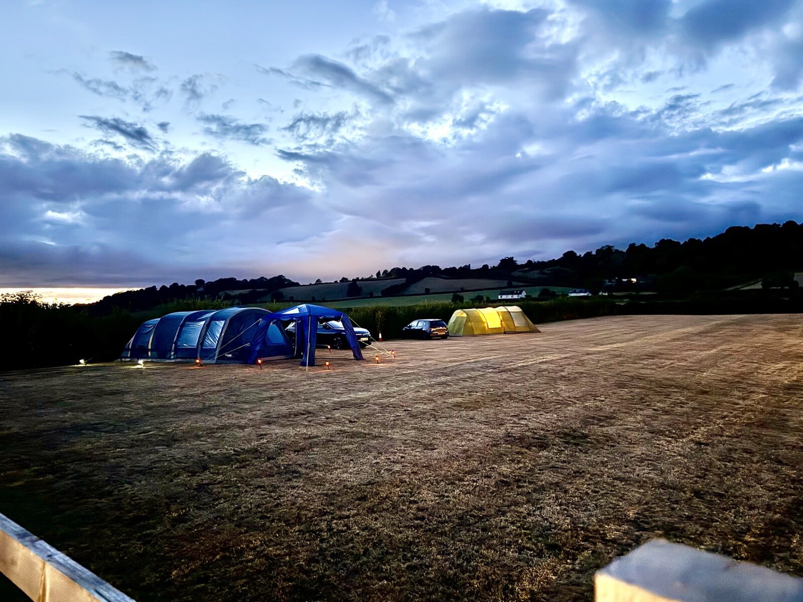 Tents pitched on the camping field under a deep blue evening sky
